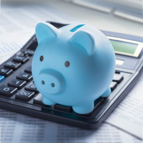 a blue piggy bank sits on a calculator