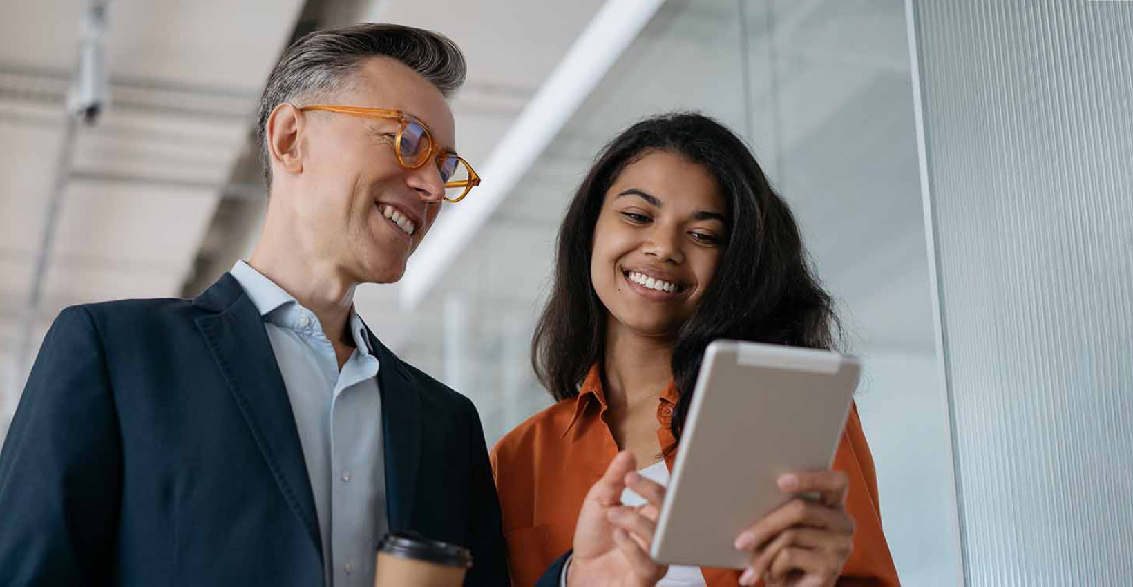 A man and a woman in an office looking at a report