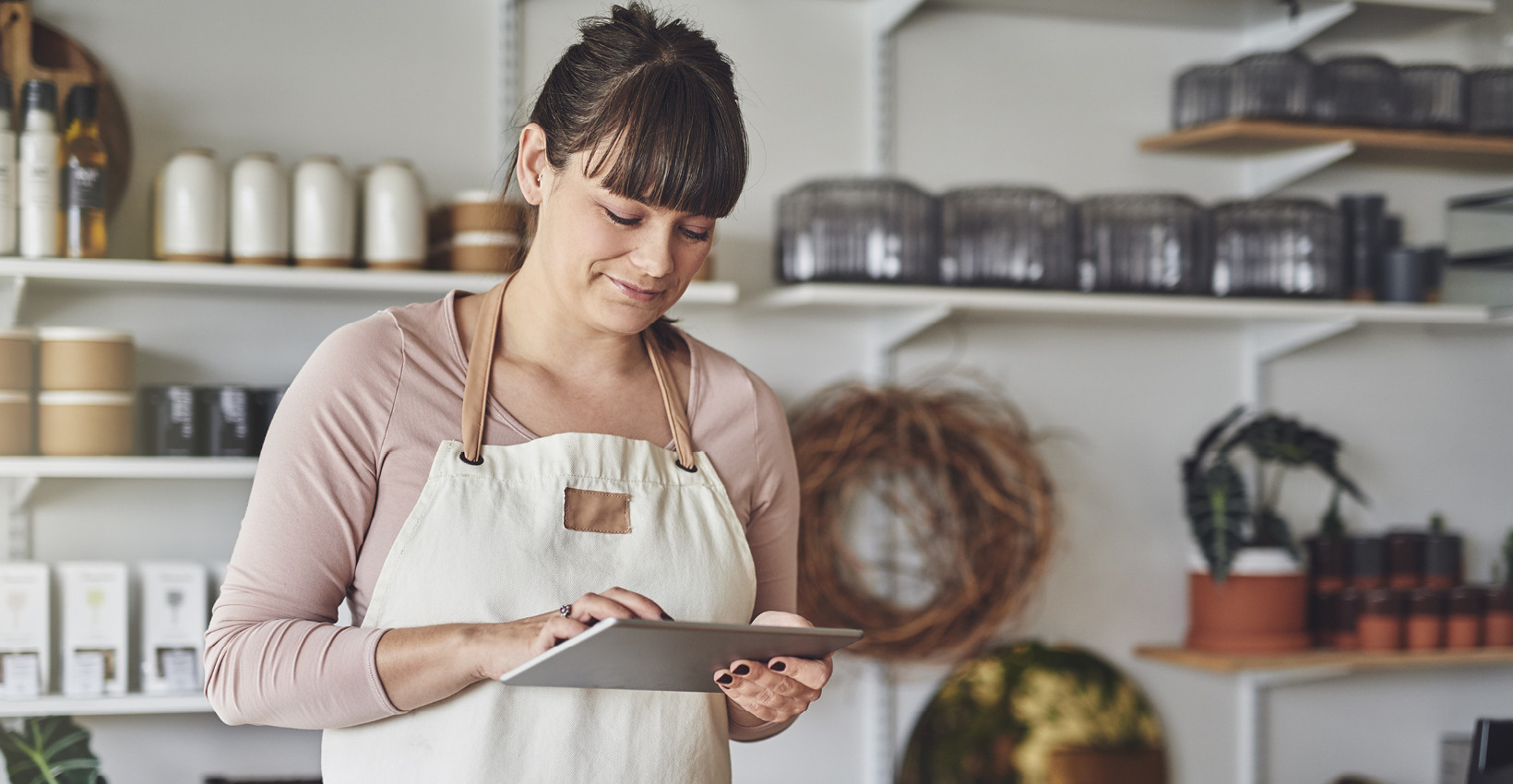 A woman using an ipad in a commercial kitchen