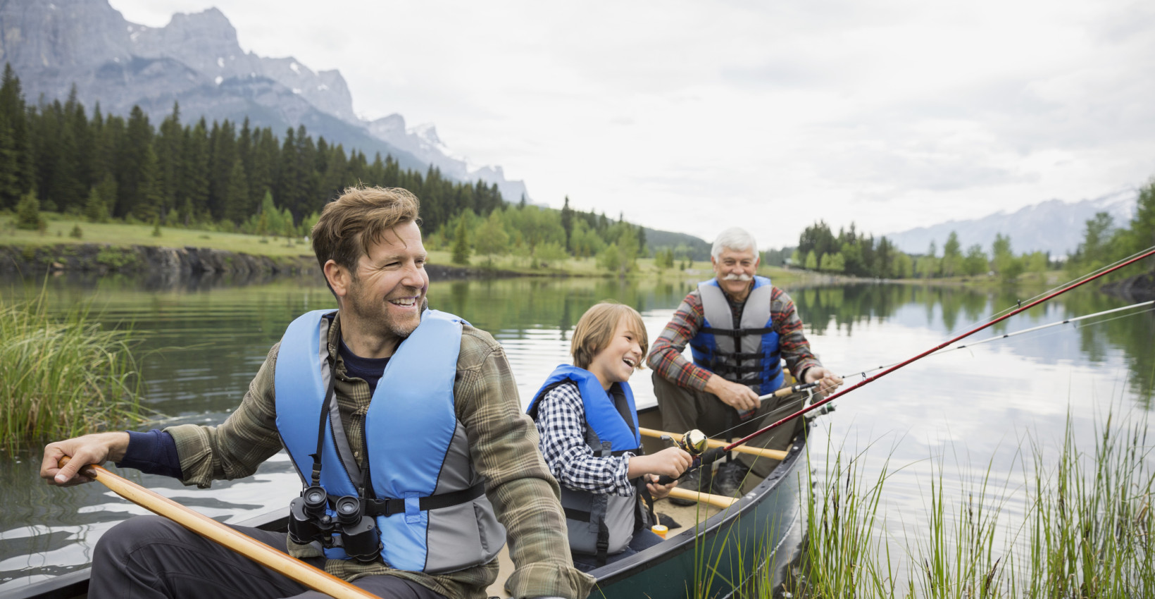 grandfather with his son and grandson in a canoe in water