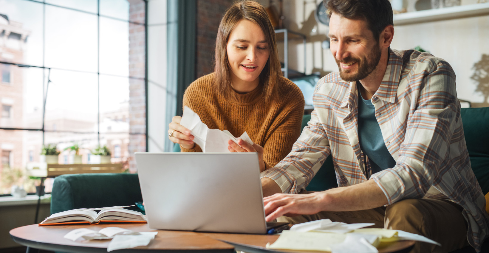 a couple looks at a computer in their living room