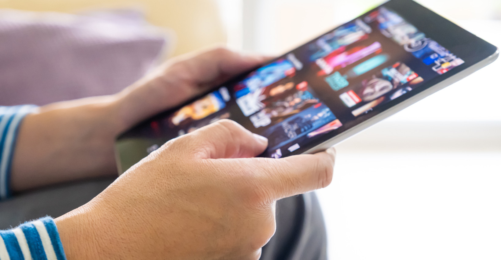 a person holds a tablet with apps pulled up