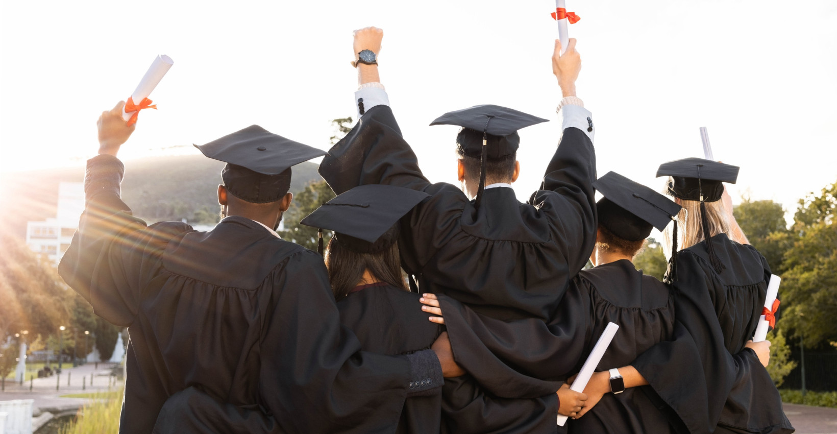 a group of graduates stand together to celebrate