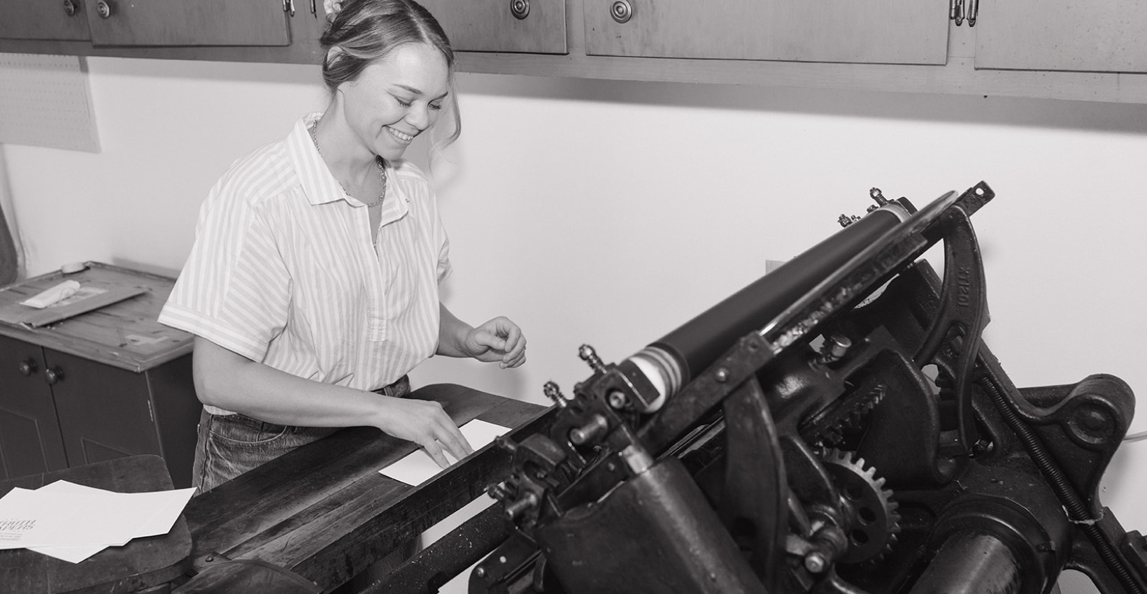 Lindsay Griepenstroh stands at her vintage letter press machine