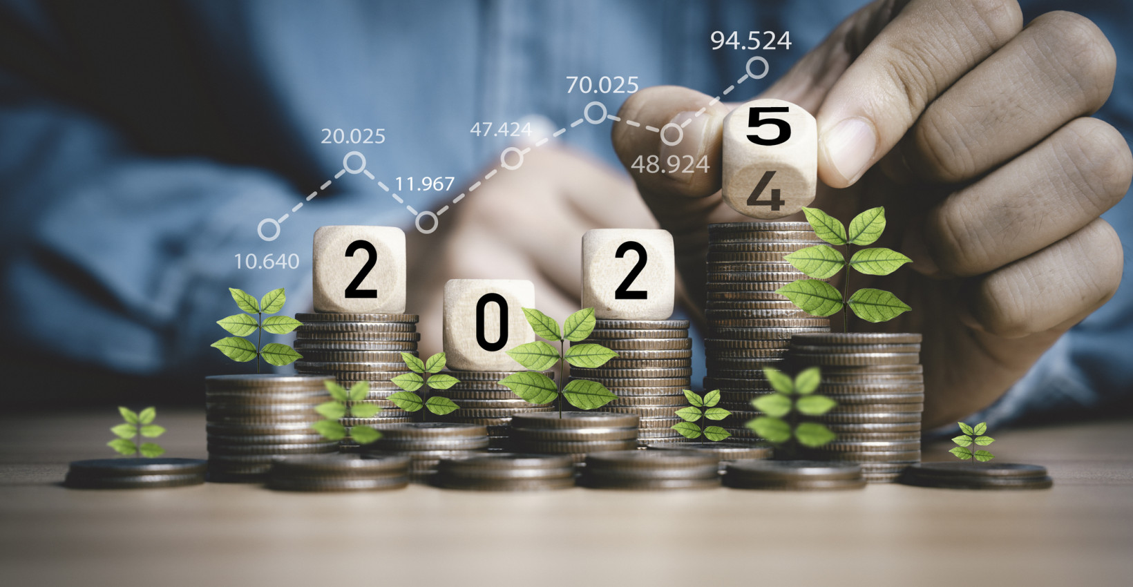 hands stack wooden blocks that say 2025 on piles of coins