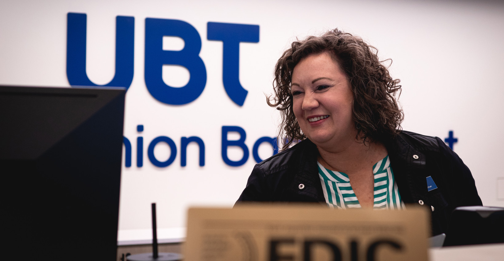 Elizabeth stands behind the teller pod at union bank place smiling