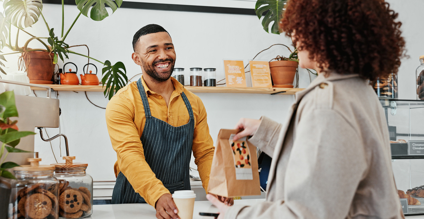 A worker helping a woman out the sales counter