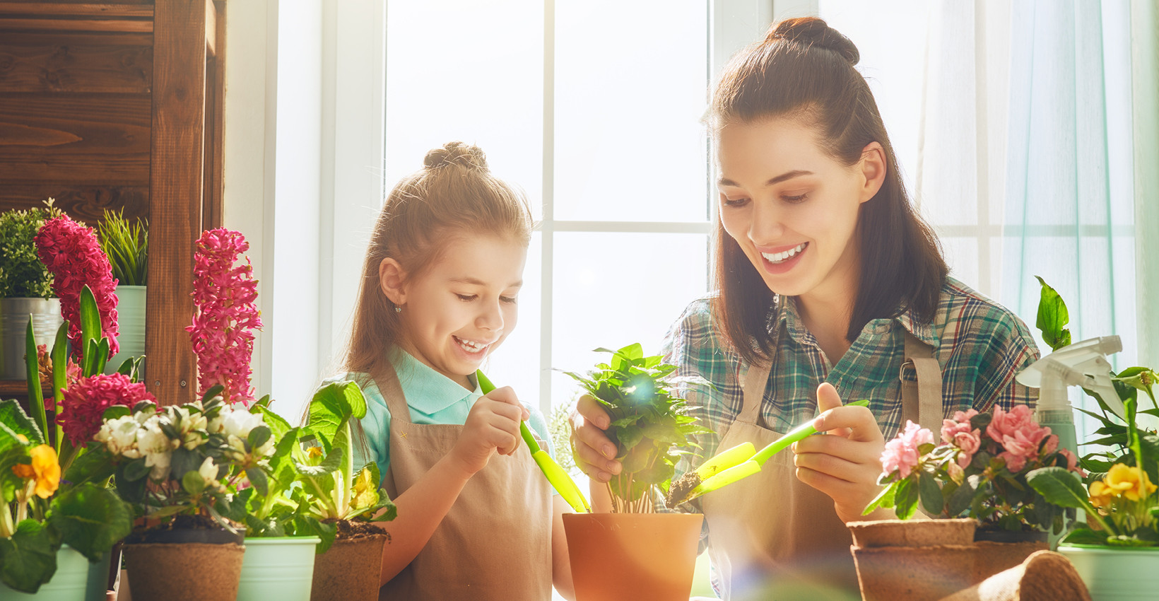 a mother and daughter sit at a table covered in flowers