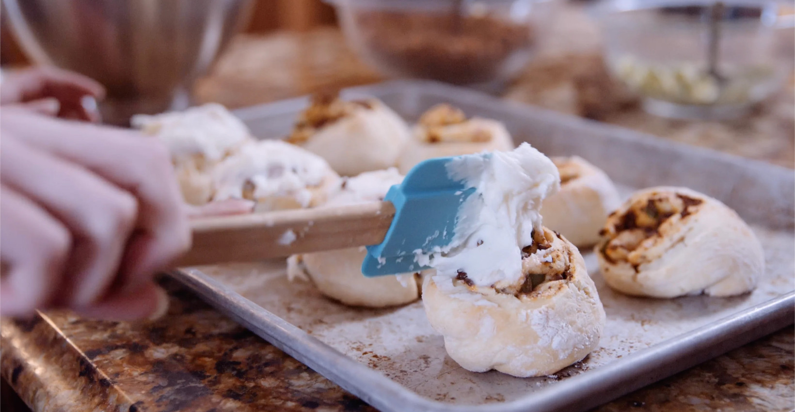 icing gets spread on a cinnamon roll