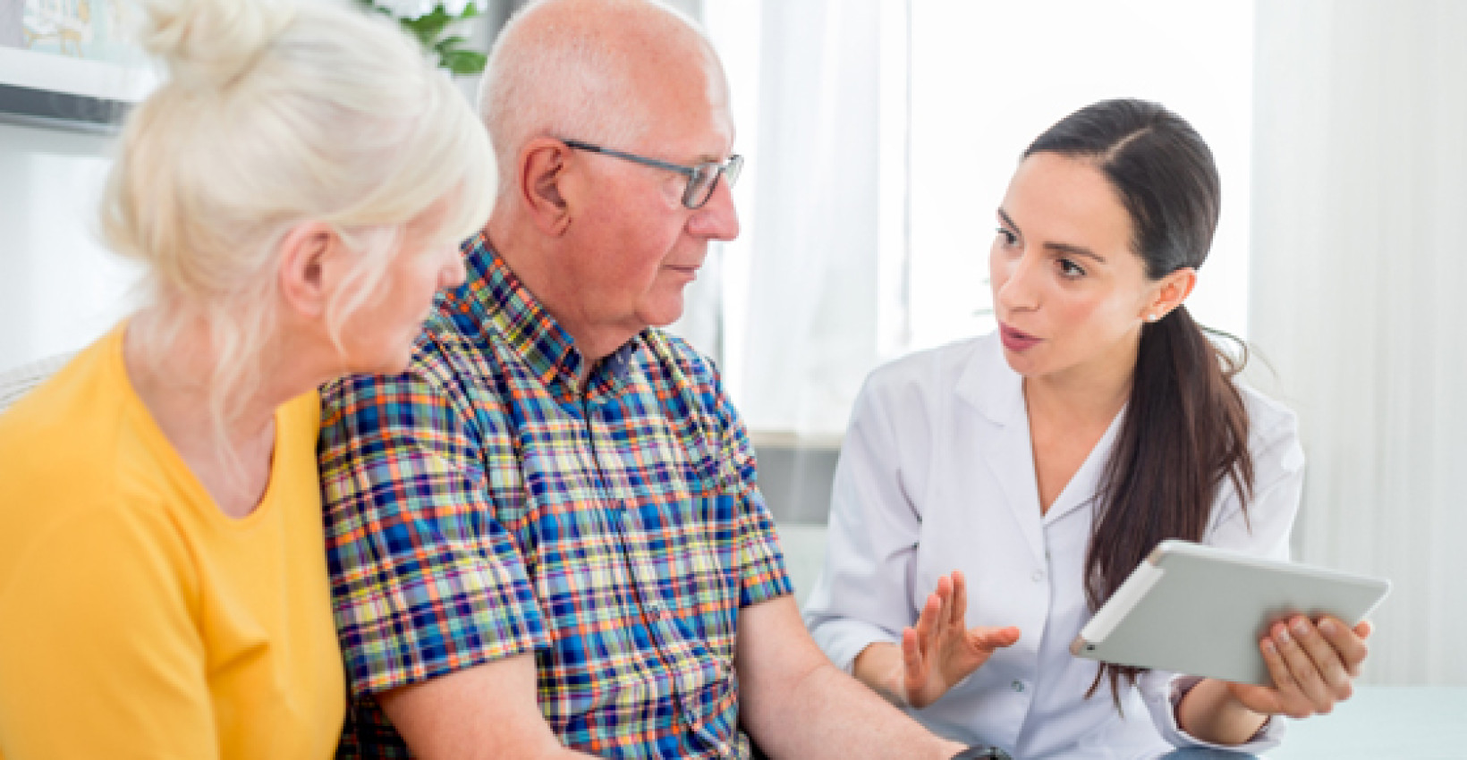 an older couple sits with a middle aged woman in conversation