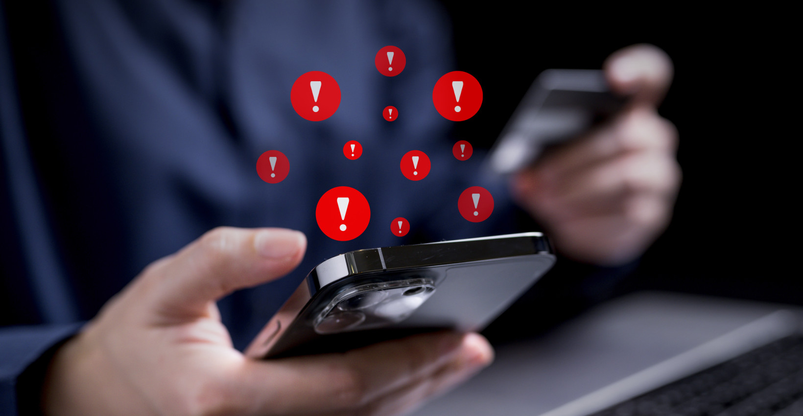 a person holds a phone with red exclamation marks coming out of it