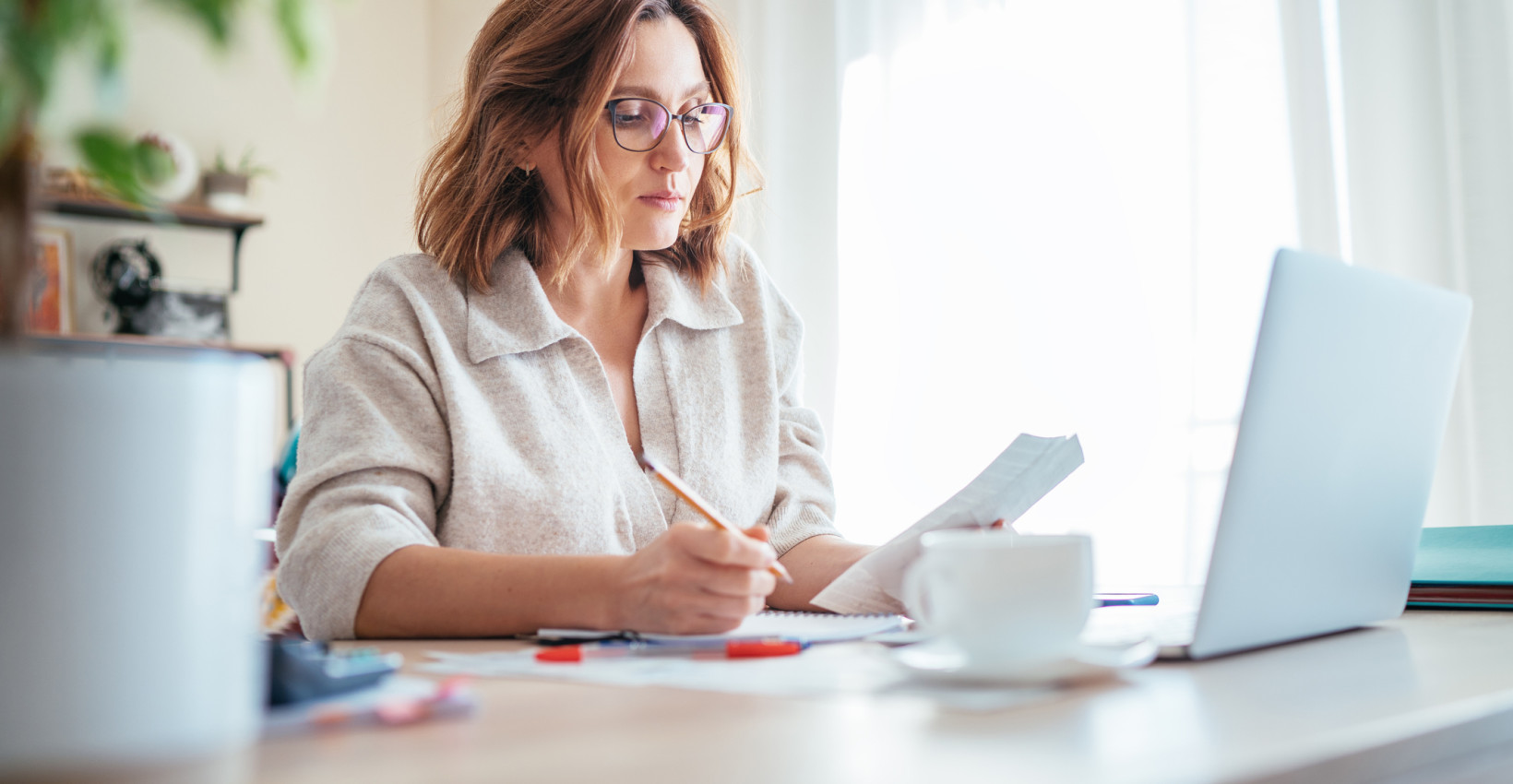 a woman sits at her laptop at a table