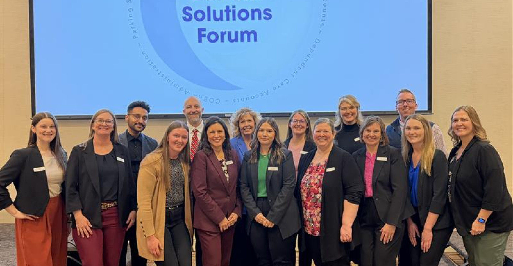 Omnify employees stand together smiling