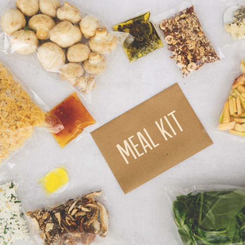 A card that says "Meal Kit" surrounded by fresh ingredients