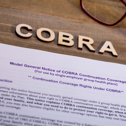 A sheet of paper about COBRA administration laying on a table