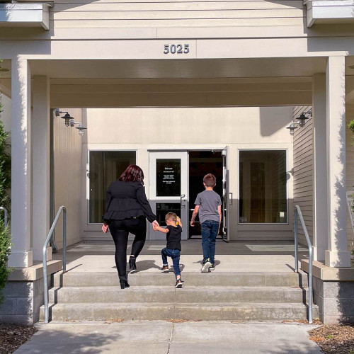 Two adults and a child walking into Child Advocacy Center