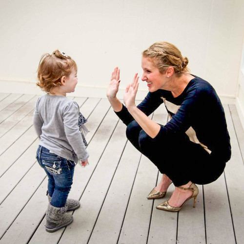 A woman giving a child a high five. 