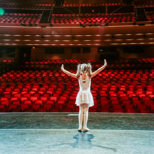 A ballerina in front of an empty auditorium.