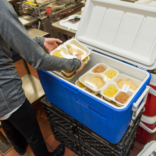 A volunteer loading food into a cooler. 