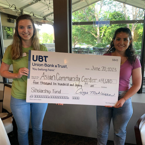 Two youths holding a giant check from UBT