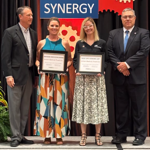 four people stand on a stage at an awards ceremony