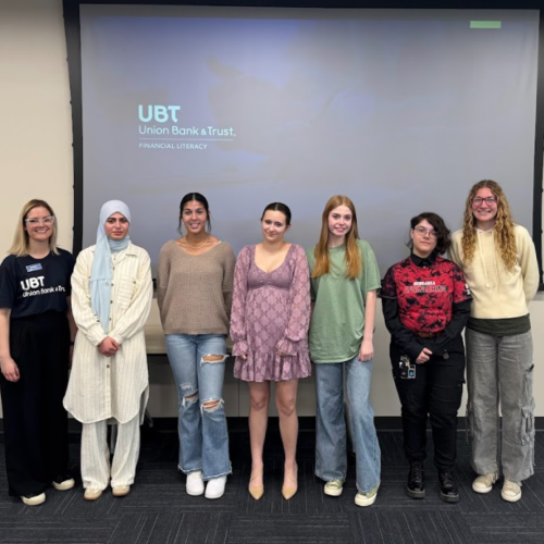a group of people stand in front of a powerpoint