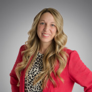A headshot of April Lewis wearing a red blazer