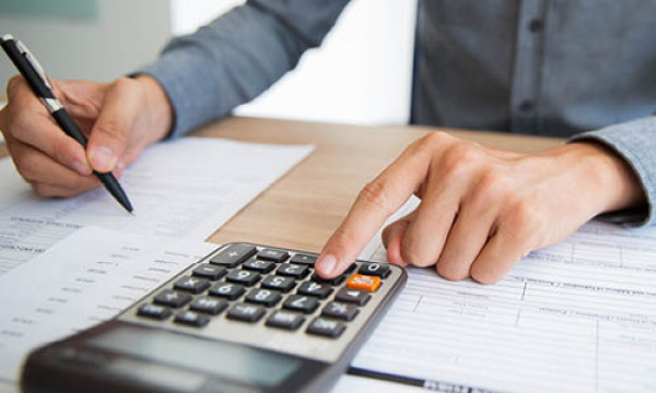 A closeup of a woman pressing a button a calculator