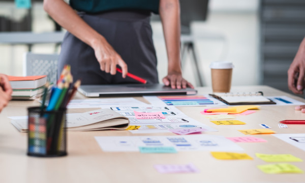 People standing around a table with business plans on them