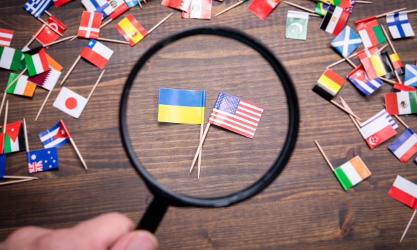 The Ukraine and American flag under a magnifying glass