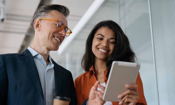 A man and a woman in an office looking at a report