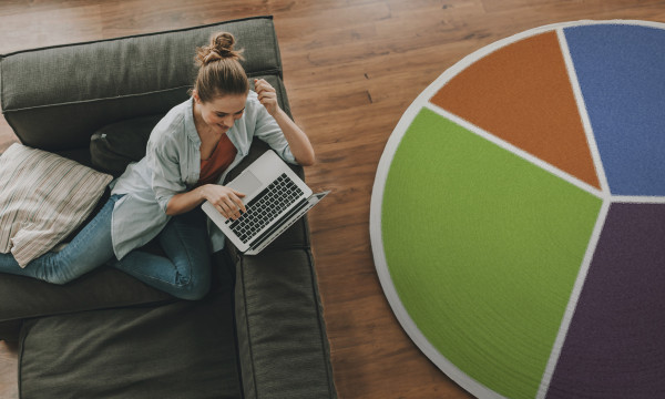 A woman sitting next to a rug that looks like a giant pie chart