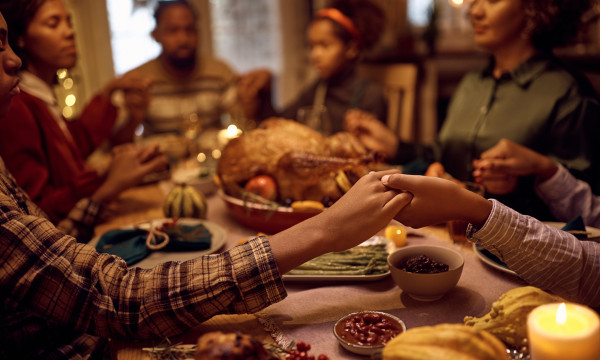 a family sits around the table for a holiday meal