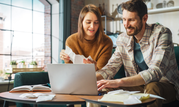 a couple looks at a computer in their living room