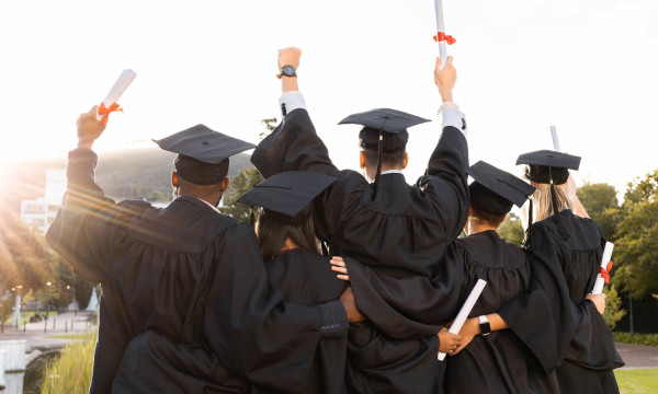 a group of graduates stand together to celebrate