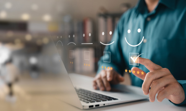 a person sits at a computer with a graphic of a check box next to them