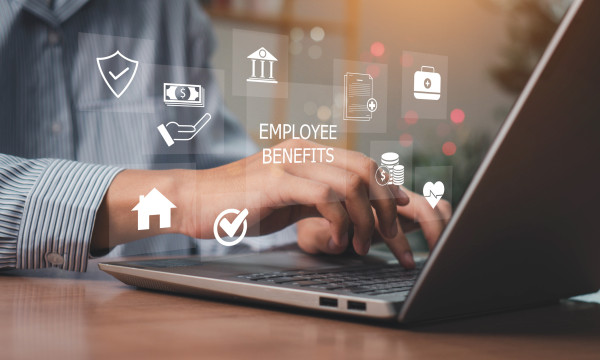 a person works at a laptop with graphics floating around on the image