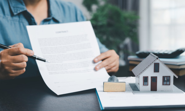 a person holds up a piece of paper and points to it with a pen