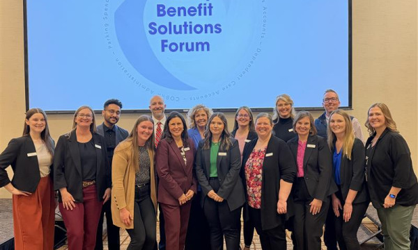 Omnify employees stand together smiling