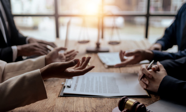 four people sit at a table with their hands visable